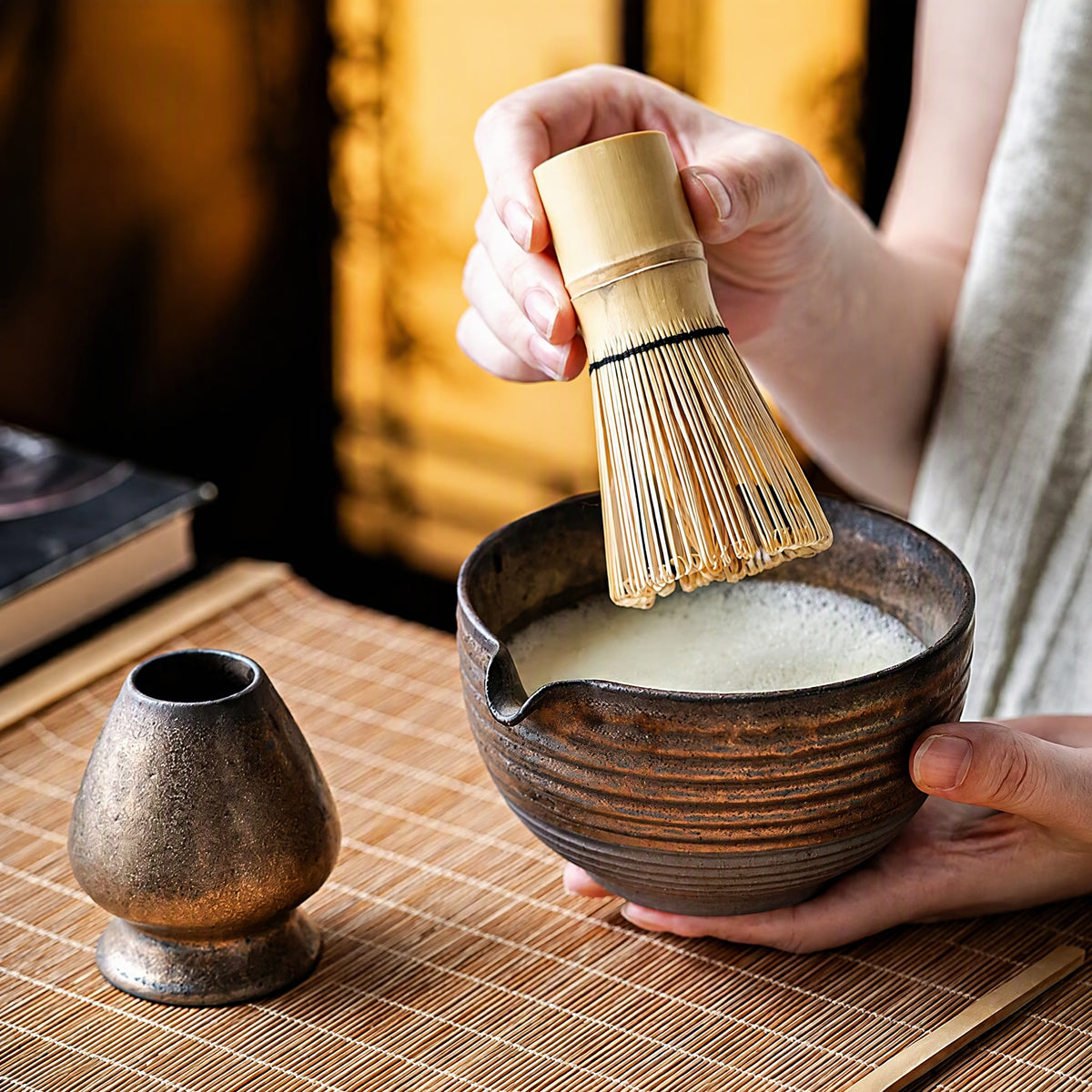 Four-piece matcha set in use: kiln-glaze bowl, bamboo whisk, whisk stand and scoop