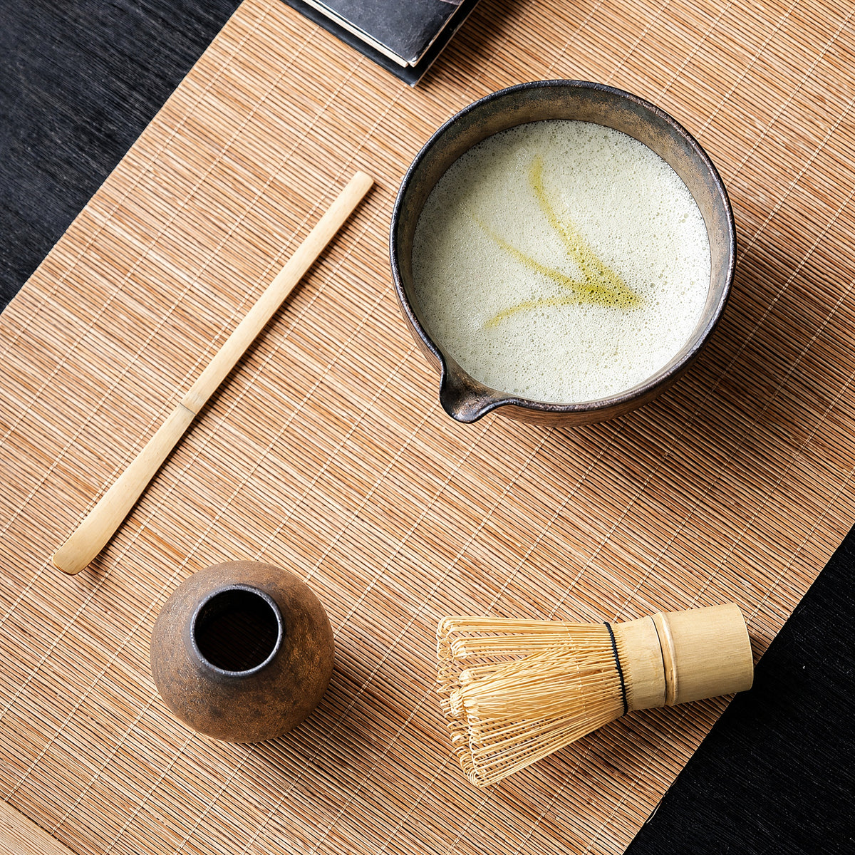 Complete four-piece kiln-glaze matcha set arranged on a tea cloth