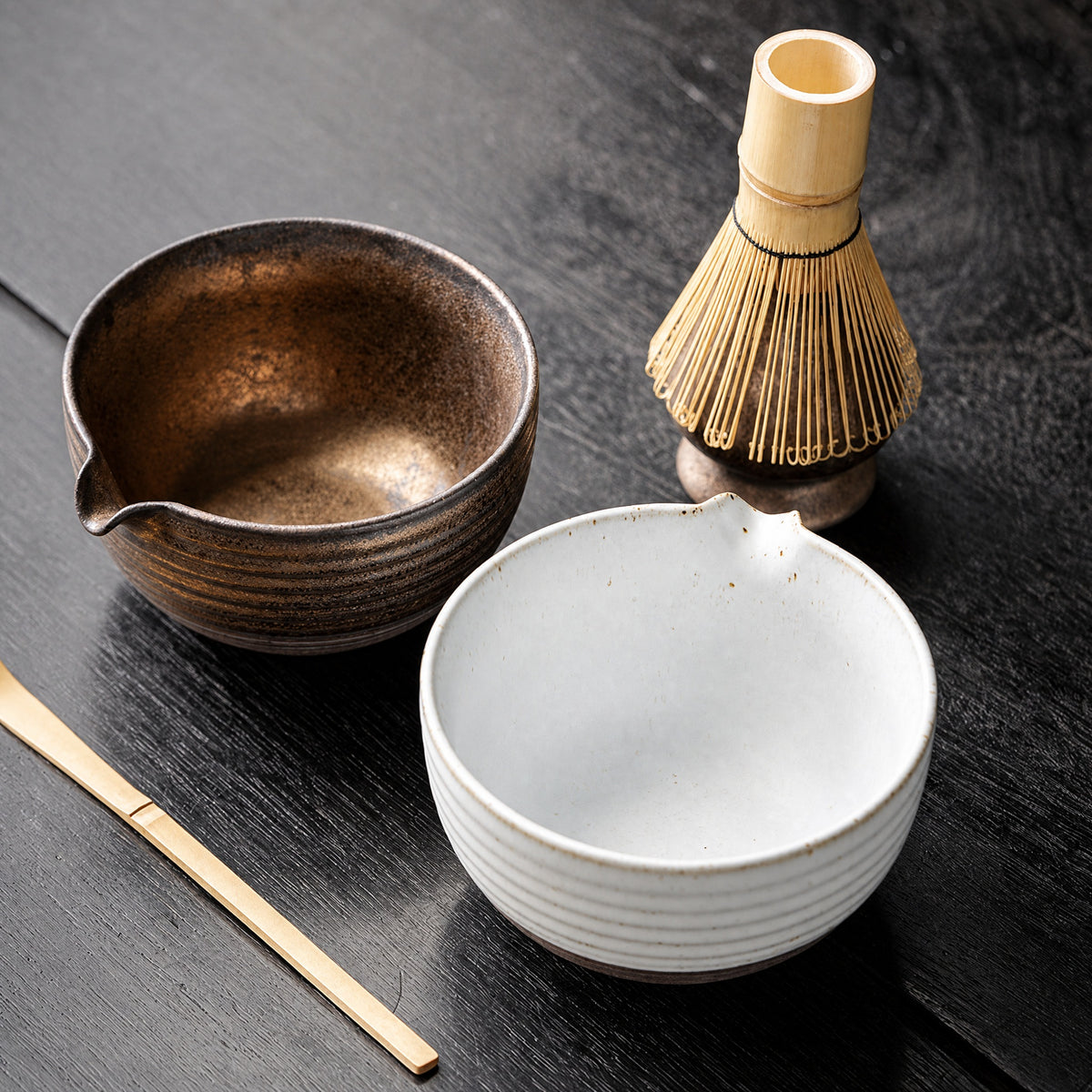 Two kiln-glaze finishes side by side: bronze and white glazed matcha bowls