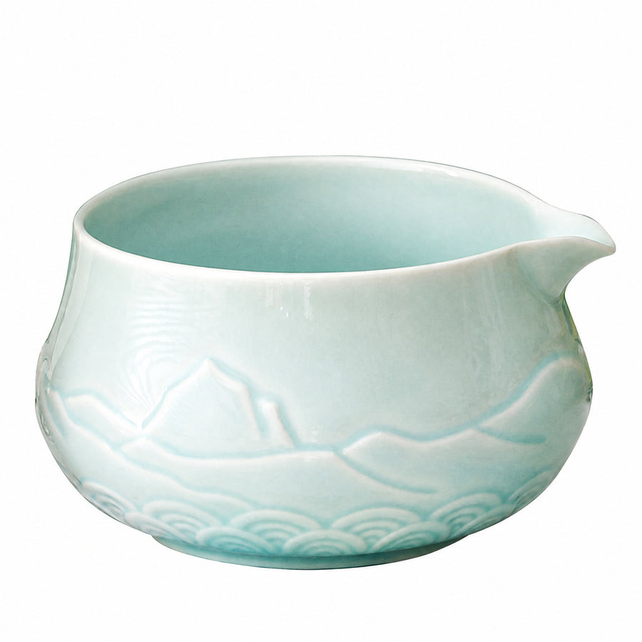 Ceramic matcha bowl with a carved distant-mountain relief pattern on a white background